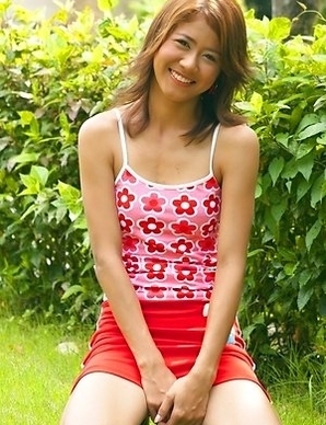 Jasmine Mookjai sits down in the garden and she spreads her legs wide. She has on white panties as she smiles at the camera.