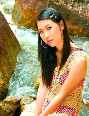 Olive Moon stands in her pink bra and she takes off her scarf. She sits down on a rock and feels on her hot body.