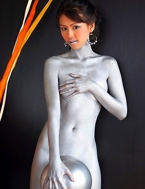 Naomi Chatee sits on a sofa completely covered in silver. This babe has an amazing body and the paint is just a masking agent for her sexiness.