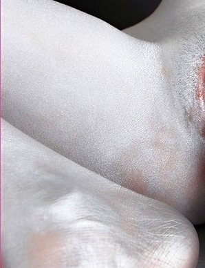 Naomi Chatee sits on a sofa completely covered in silver. This babe has an amazing body and the paint is just a masking agent for her sexiness.